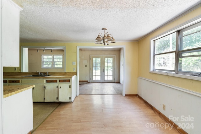 kitchen featuring an inviting chandelier, a wealth of natural light, and light hardwood / wood-style floors