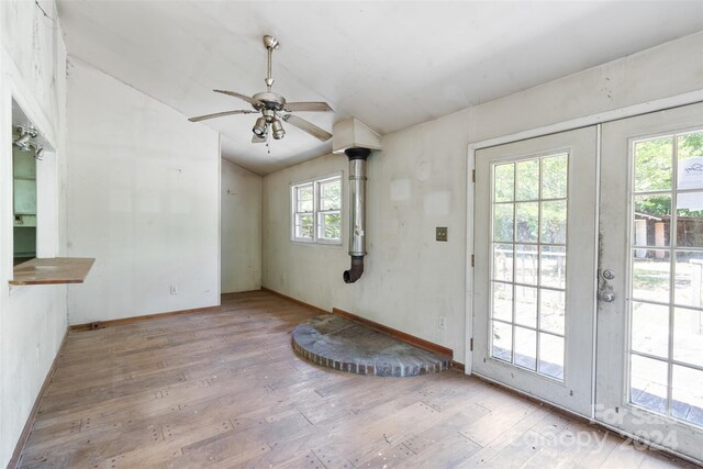 doorway featuring ceiling fan, light hardwood / wood-style flooring, lofted ceiling, and a wealth of natural light