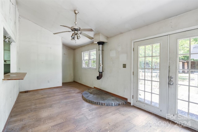 interior space with ceiling fan, vaulted ceiling, and light hardwood / wood-style flooring