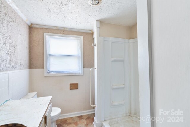 bathroom with vanity, a textured ceiling, and toilet