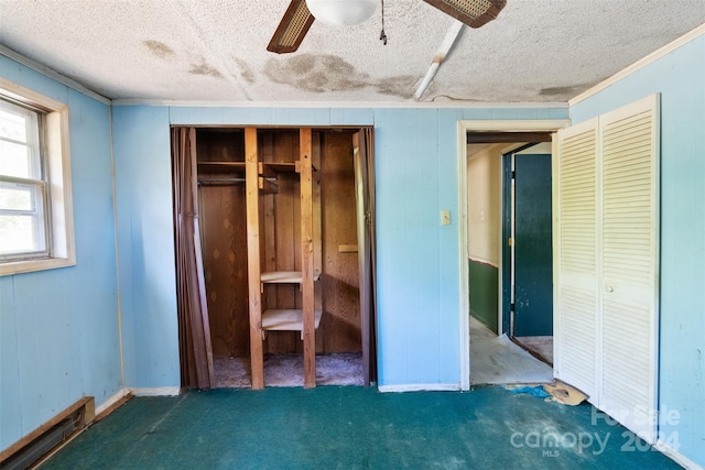 unfurnished bedroom featuring ceiling fan, dark carpet, a closet, and a textured ceiling