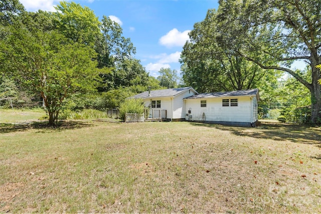 back of property with a yard and a deck