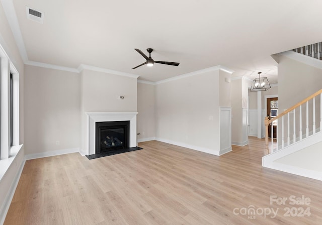 unfurnished living room with crown molding, ceiling fan with notable chandelier, and light hardwood / wood-style flooring