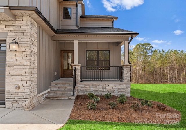 doorway to property featuring a porch and a yard