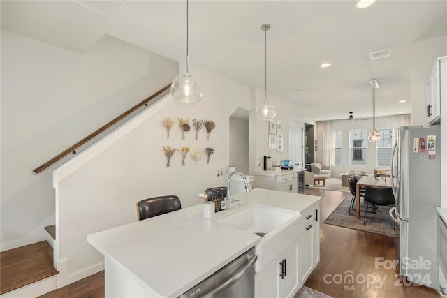 kitchen with appliances with stainless steel finishes, dark hardwood / wood-style floors, sink, an island with sink, and white cabinets