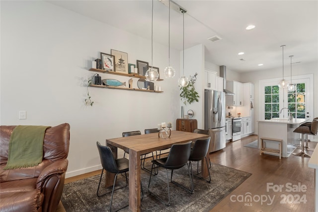 dining space featuring sink and dark wood-type flooring