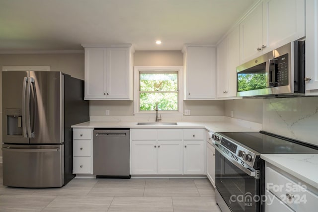 kitchen featuring light stone counters, sink, stainless steel appliances, and white cabinets