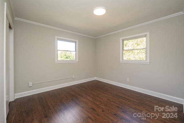 unfurnished room featuring a wealth of natural light, dark hardwood / wood-style floors, and crown molding