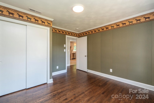 empty room with crown molding and dark hardwood / wood-style flooring