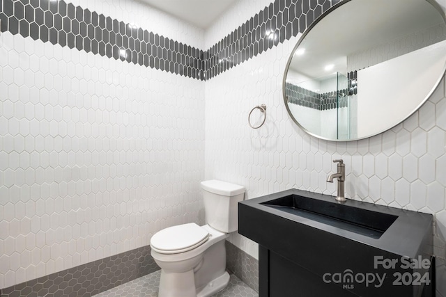 bathroom featuring tile walls, a shower, tile patterned floors, vanity, and toilet