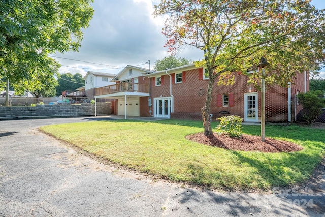 back of house featuring a lawn, french doors, and a garage