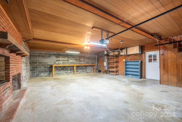 garage with a garage door opener, a workshop area, and water heater