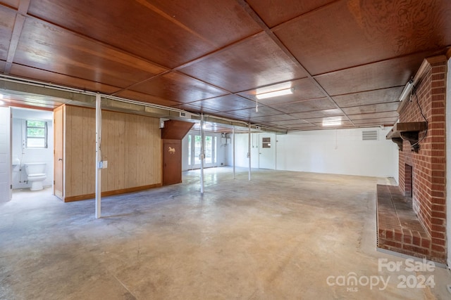 basement featuring a fireplace and wood walls