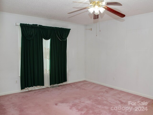 spare room featuring a textured ceiling, ceiling fan, and carpet floors