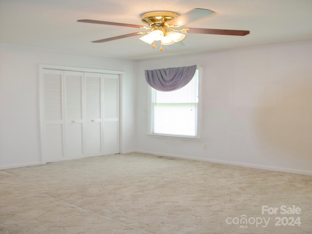 unfurnished bedroom with ceiling fan, carpet flooring, and a closet