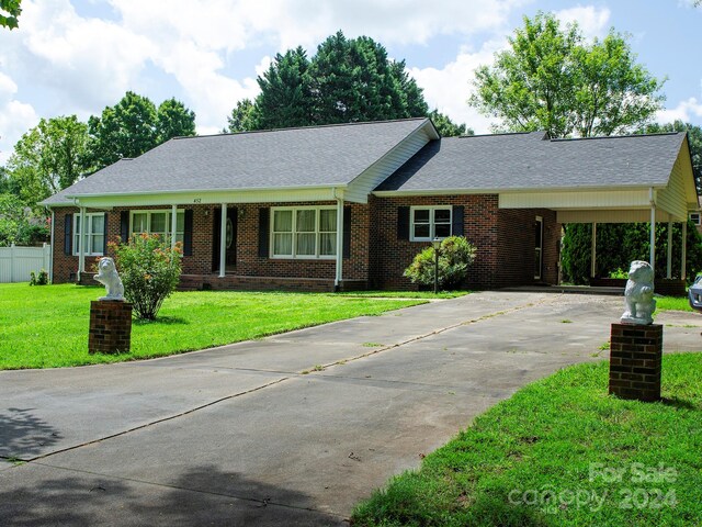 single story home featuring a carport and a front lawn