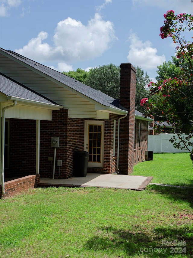 back of property featuring a patio area and a lawn