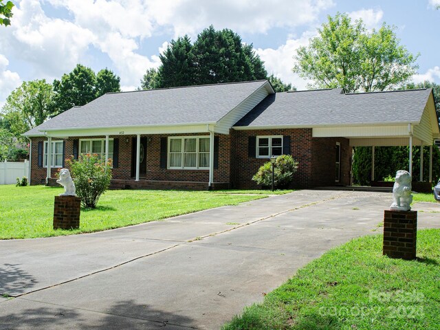 ranch-style home featuring a front yard and a carport