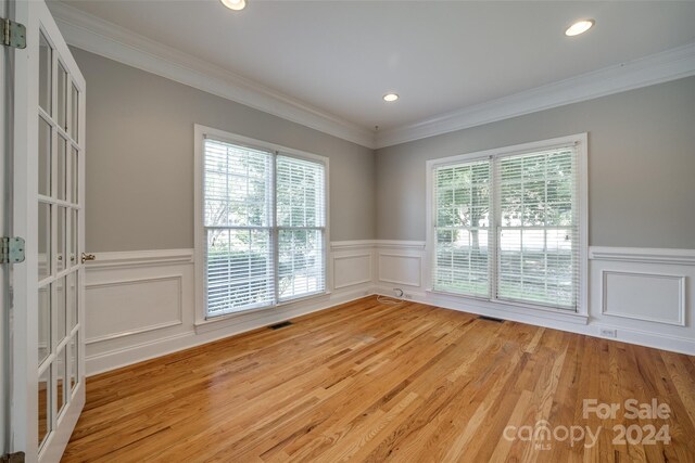 unfurnished room featuring light wood-type flooring and ornamental molding