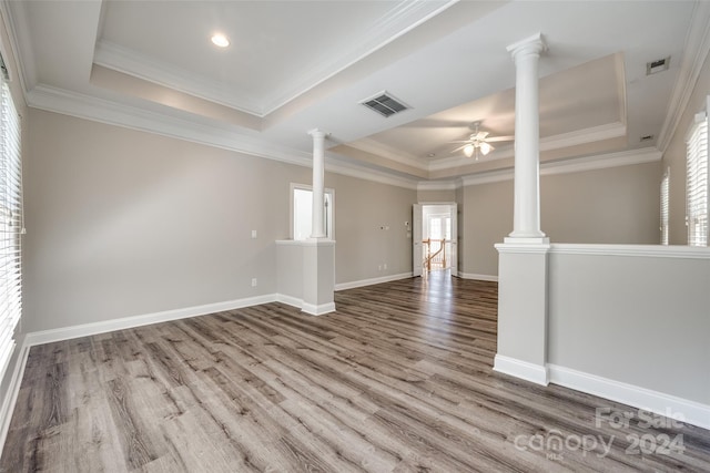 unfurnished room with crown molding, hardwood / wood-style floors, ceiling fan, and a raised ceiling