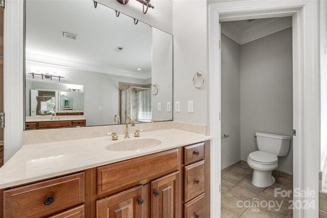 bathroom featuring crown molding, vanity, tile patterned flooring, and toilet