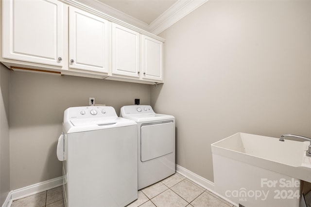 laundry area with light tile patterned flooring, cabinets, ornamental molding, and washing machine and dryer