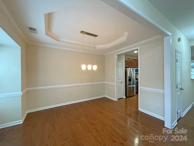 unfurnished room featuring ornamental molding, dark hardwood / wood-style floors, and a tray ceiling