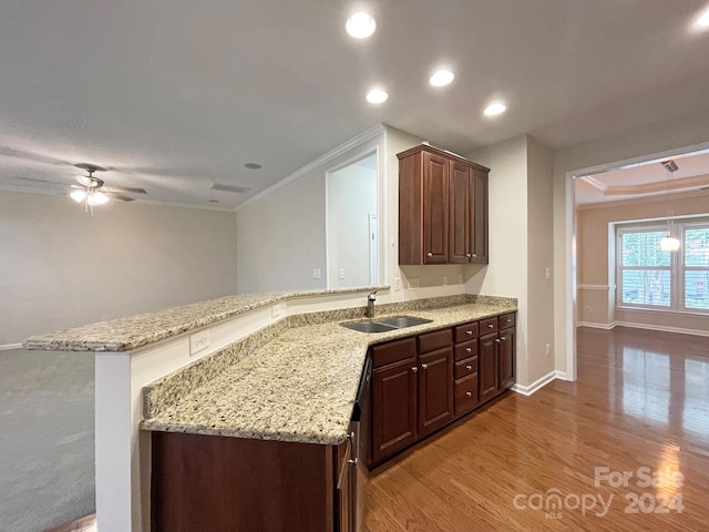 kitchen with sink, kitchen peninsula, ceiling fan, crown molding, and light hardwood / wood-style flooring