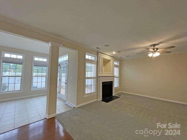 unfurnished living room with ornate columns, light hardwood / wood-style floors, ornamental molding, and ceiling fan