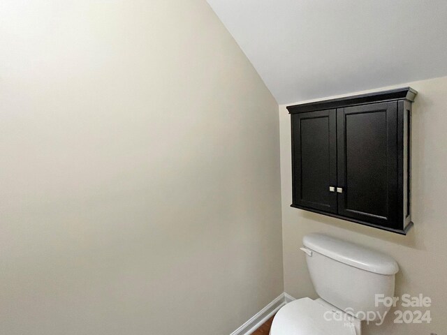 bathroom featuring toilet and lofted ceiling