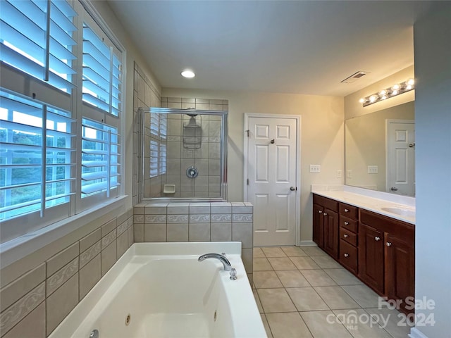 bathroom featuring a wealth of natural light, vanity, plus walk in shower, and tile patterned flooring