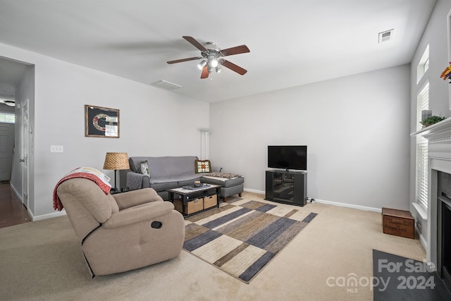 carpeted living room with ceiling fan