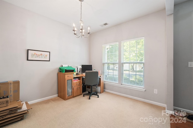 carpeted office featuring an inviting chandelier