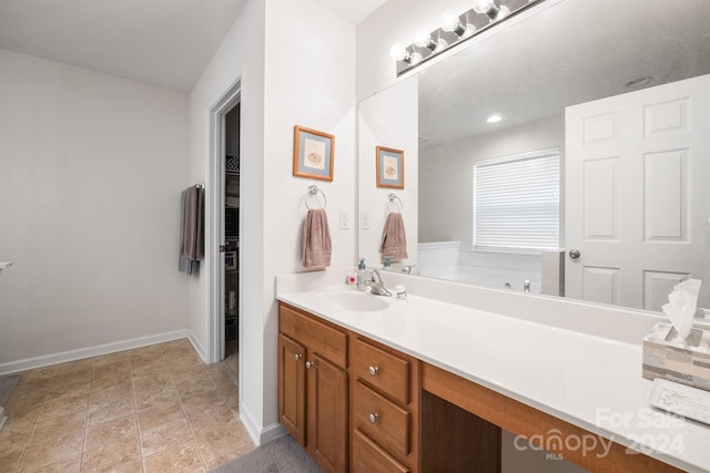 bathroom with vanity, tile patterned flooring, and a bathtub