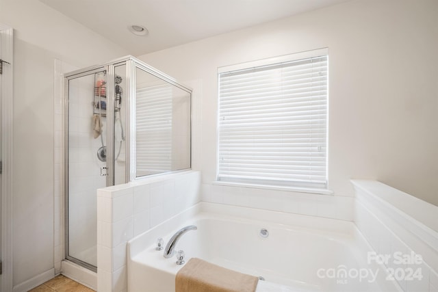 bathroom with separate shower and tub and tile patterned floors