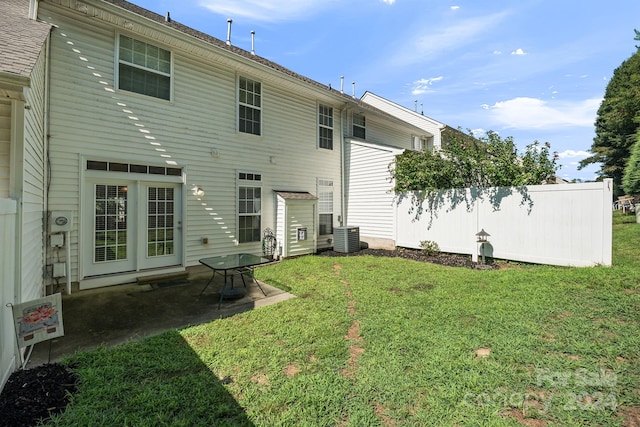 rear view of property featuring a patio, a lawn, and central AC unit