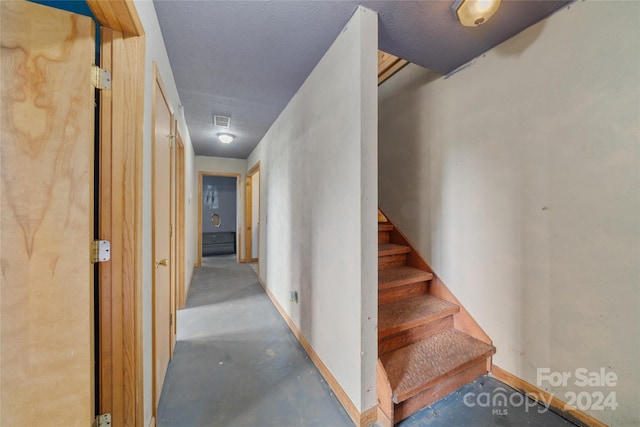 hallway featuring concrete floors and a textured ceiling