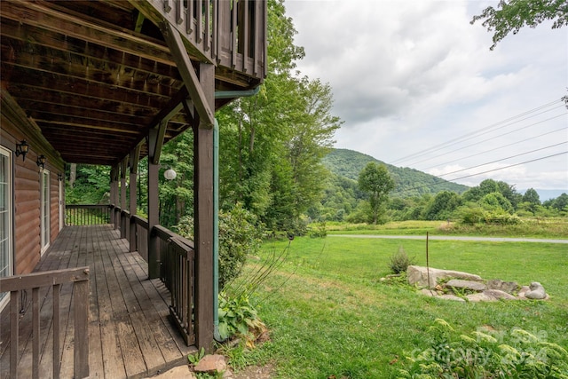 wooden terrace featuring a lawn