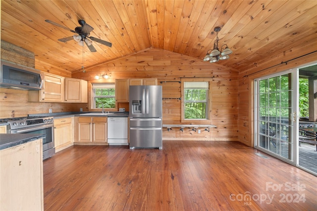 kitchen with ceiling fan, wood walls, stainless steel appliances, light brown cabinetry, and dark hardwood / wood-style flooring