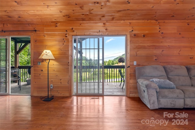 doorway to outside featuring wood-type flooring, wood ceiling, and wooden walls