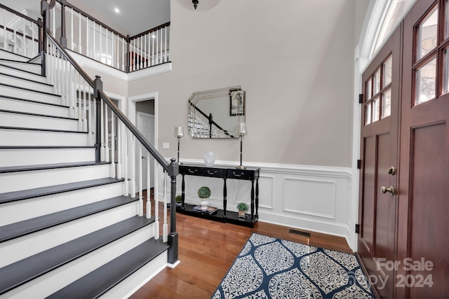 entryway with a towering ceiling and dark hardwood / wood-style flooring