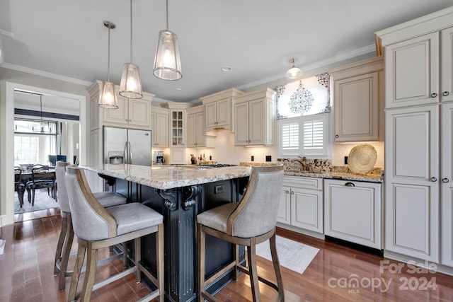 kitchen featuring appliances with stainless steel finishes, a healthy amount of sunlight, a kitchen island, and dark hardwood / wood-style floors