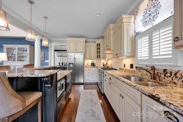 kitchen featuring a breakfast bar, sink, stainless steel appliances, decorative light fixtures, and dark hardwood / wood-style flooring