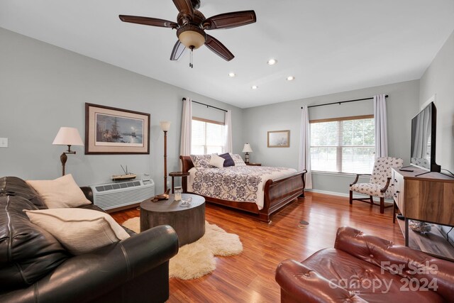 bedroom featuring multiple windows, light hardwood / wood-style floors, and ceiling fan