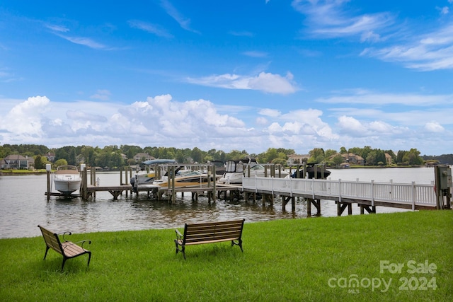 view of dock with a lawn and a water view