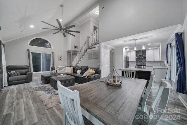 dining area with crown molding, ceiling fan, sink, light hardwood / wood-style floors, and beamed ceiling