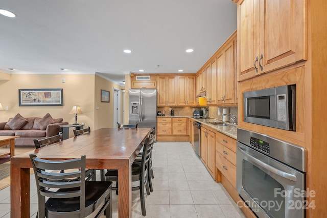 kitchen featuring ornamental molding, recessed lighting, appliances with stainless steel finishes, light tile patterned floors, and decorative backsplash