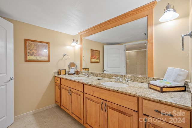 bathroom with a sink, baseboards, double vanity, and tile patterned floors