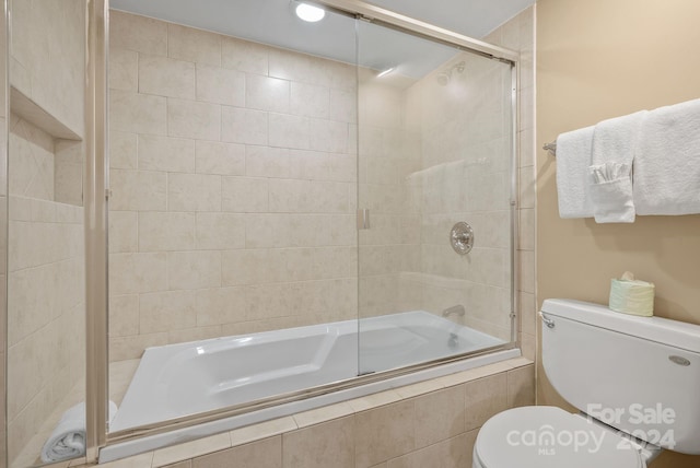 bathroom with toilet and tiled shower / bath combo