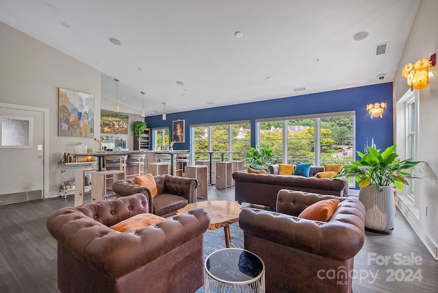 living area featuring a wealth of natural light, visible vents, and wood finished floors